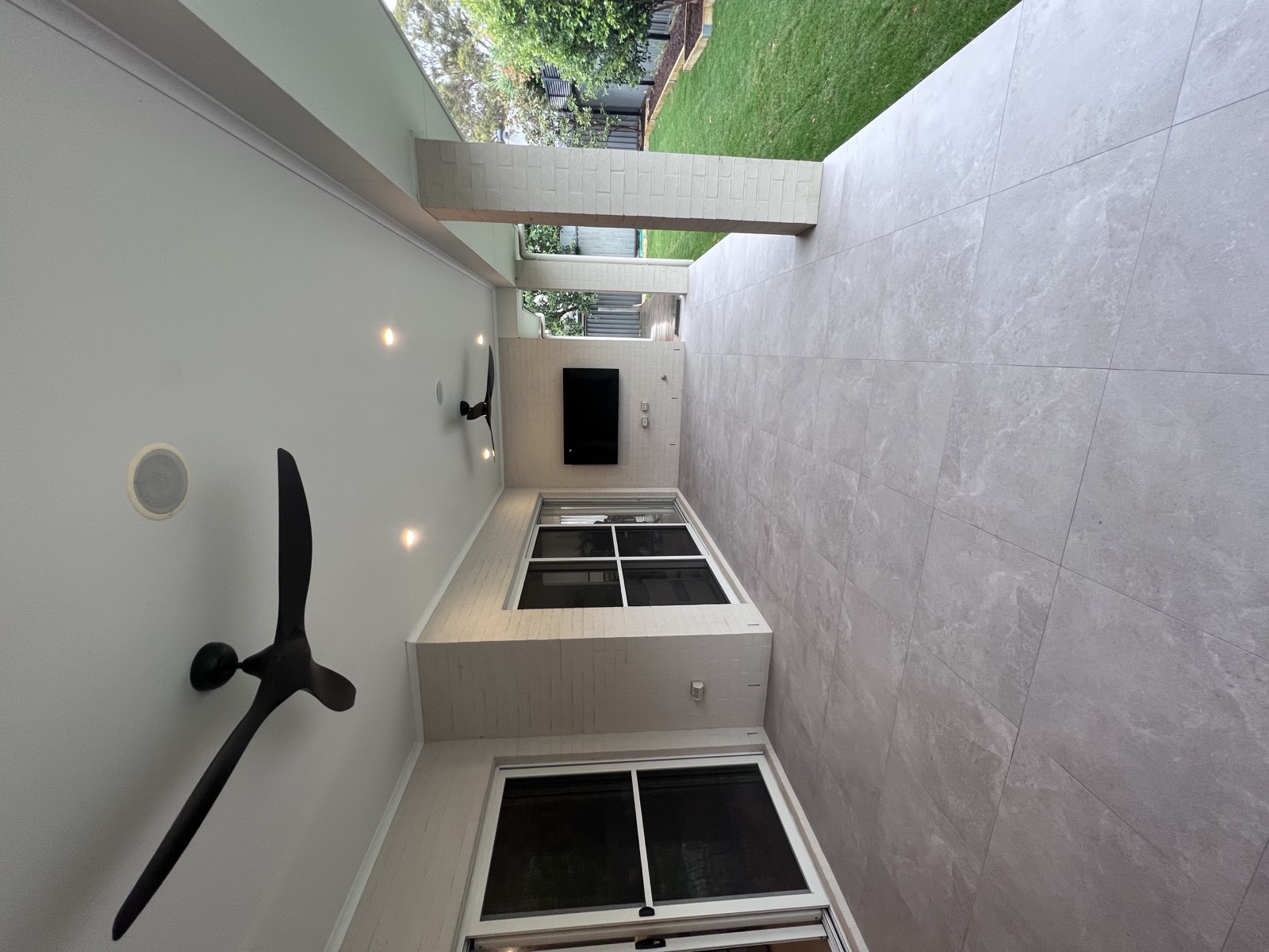 Finished alfresco area with ceiling downlights, outdoor ceiling fan and mounted TV — Sydney install